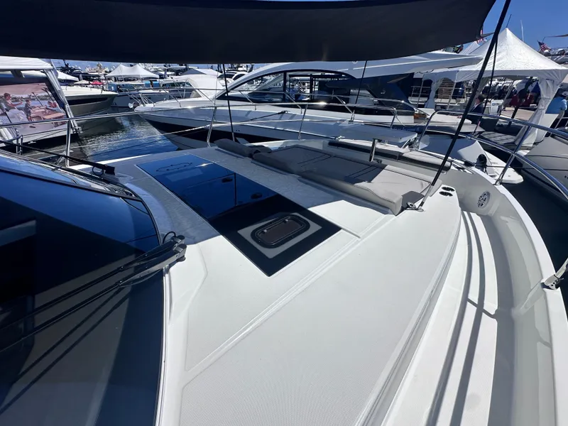 Slide: The Image of 2025 Jeanneau 1295 yacht deck at a marina, showcasing sleek design and modern features. - 8