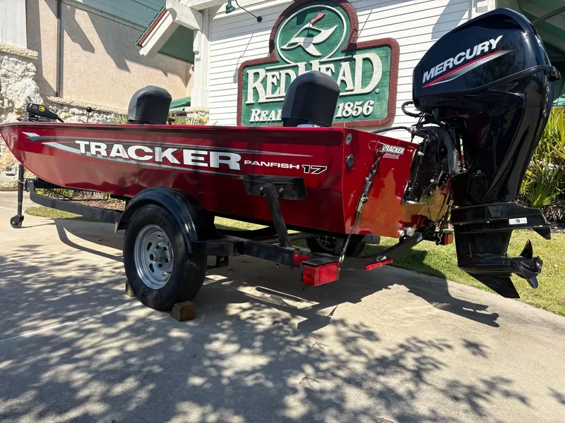 Slide: The Image of 2025 Tracker Panfish 17 boat with Mercury engine, parked outdoors. - 3