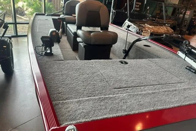Slide: The Image of 2025 Tracker Panfish 17 boat with gray carpeted deck and seating, displayed indoors. - 4