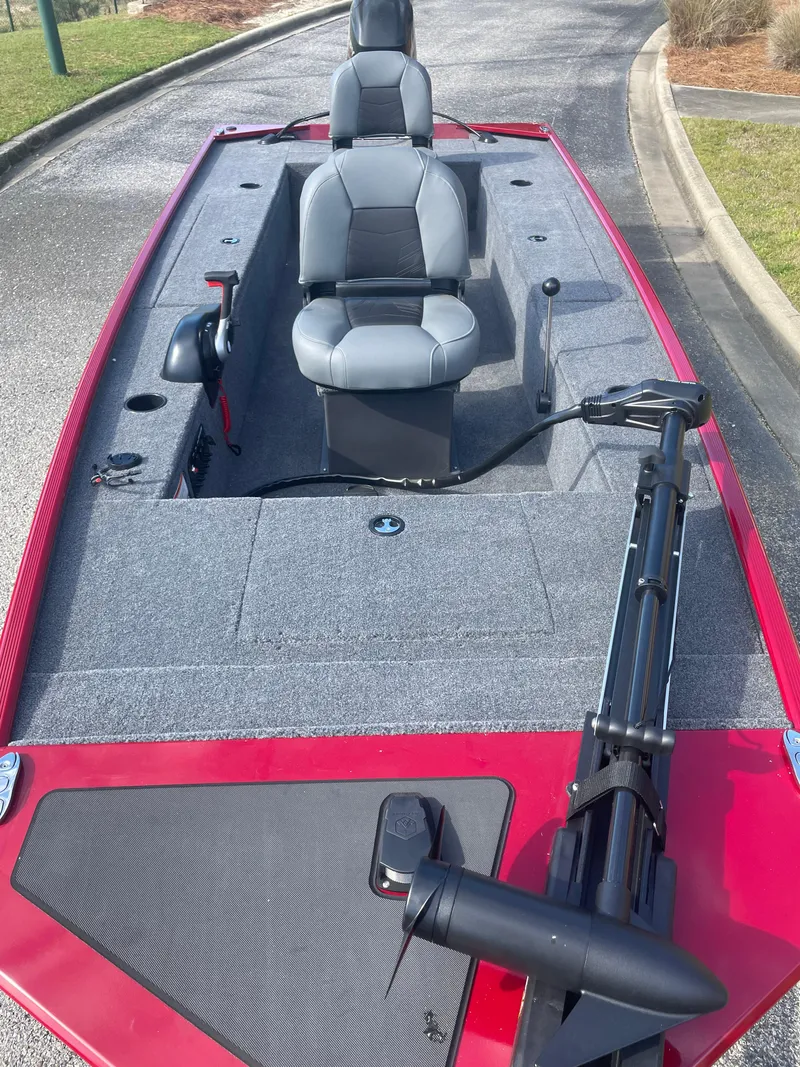 Slide: The Image of 2025 Tracker Panfish 17 boat with gray seating and red trim, featuring a trolling motor. - 3