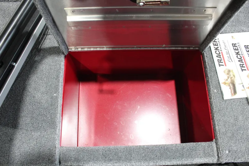 Slide: The Image of Open storage compartment in 2025 Tracker Panfish 17 boat, featuring red interior and gray carpet. - 20