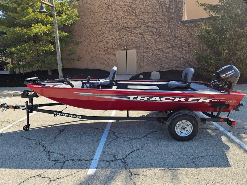 The Image of 2025 Tracker Panfish 17 boat in parking lot, red exterior, on trailer. - 0