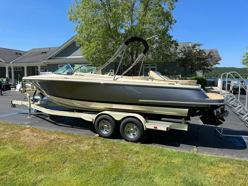 Slide: The Image of 2023 Chris-Craft Launch 25 GT boat on trailer, parked outdoors near a building. - 0