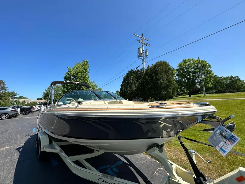 Slide: The Image of 2023 Chris-Craft Launch 25 GT boat on trailer, parked outdoors under clear blue sky. - 4