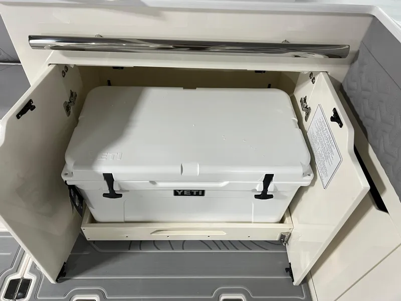 Slide: The Image of White YETI cooler stored in a 2025 Regal LS36 boat compartment. - 12