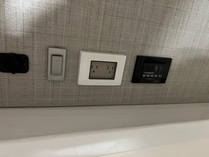 Slide: The Image of Control panel and outlets on 2025 Regal LS36 boat interior wall. - 34