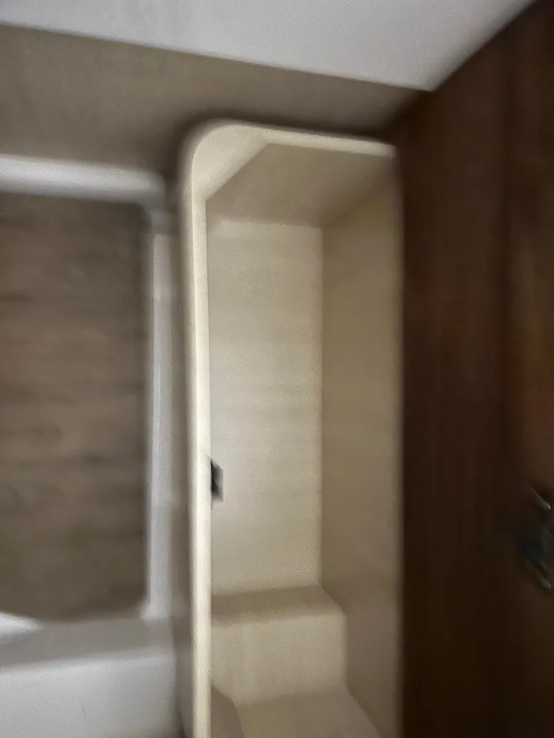 Slide: The Image of Interior view of 2025 Regal LS36 boat cabin with wooden and beige finishes. - 40