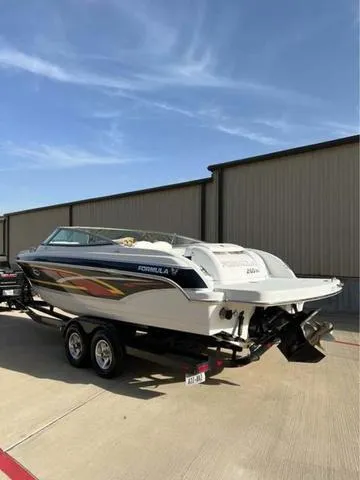 Slide: The Image of 2008 Formula 260 Bow Rider boat on trailer, parked outdoors under clear blue sky. - 12