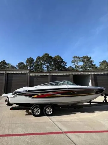 Slide: The Image of 2008 Formula 260 Bow Rider boat on trailer, parked outdoors under clear blue sky. - 20