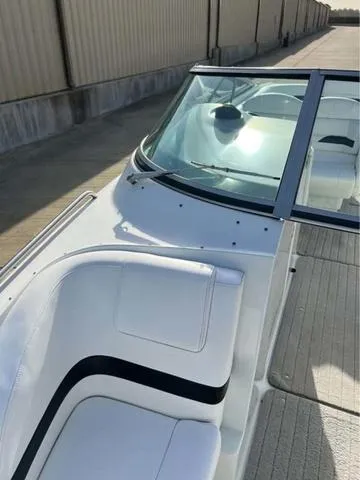 Slide: The Image of 2008 Formula 260 Bow Rider boat with white seating and windshield, docked near a warehouse. - 3