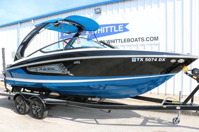 Slide: The Image of 2018 Regal 23 RX Surf boat in blue and black on a trailer. - 14