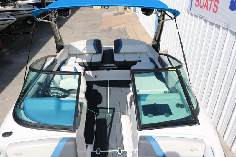 Slide: The Image of 2018 Regal 23 RX Surf boat with blue accents and open seating layout. - 29