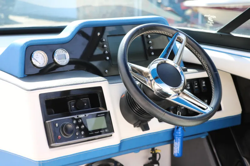 Slide: The Image of 2018 Regal 23 RX Surf boat dashboard with steering wheel and control panel. - 33
