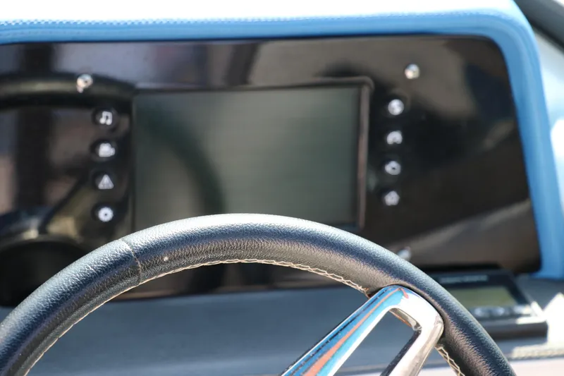 Slide: The Image of Dashboard of a 2018 Regal 23 RX Surf boat with steering wheel and control panel. - 38