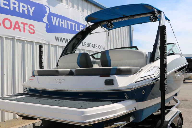 Slide: The Image of 2018 Regal 23 RX Surf boat with blue canopy, displayed at dealership. - 4