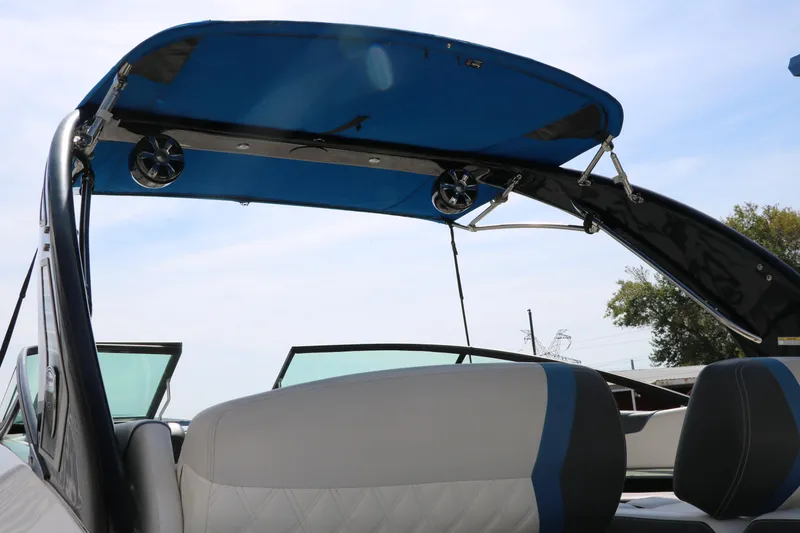 Slide: The Image of 2018 Regal 23 RX Surf boat interior with blue canopy and speakers. - 8