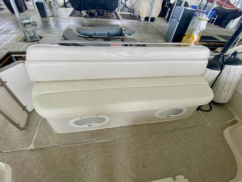 Slide: The Image of 2001 Regal Commodore 4160 boat seating area with white cushioned bench and speakers. - 14