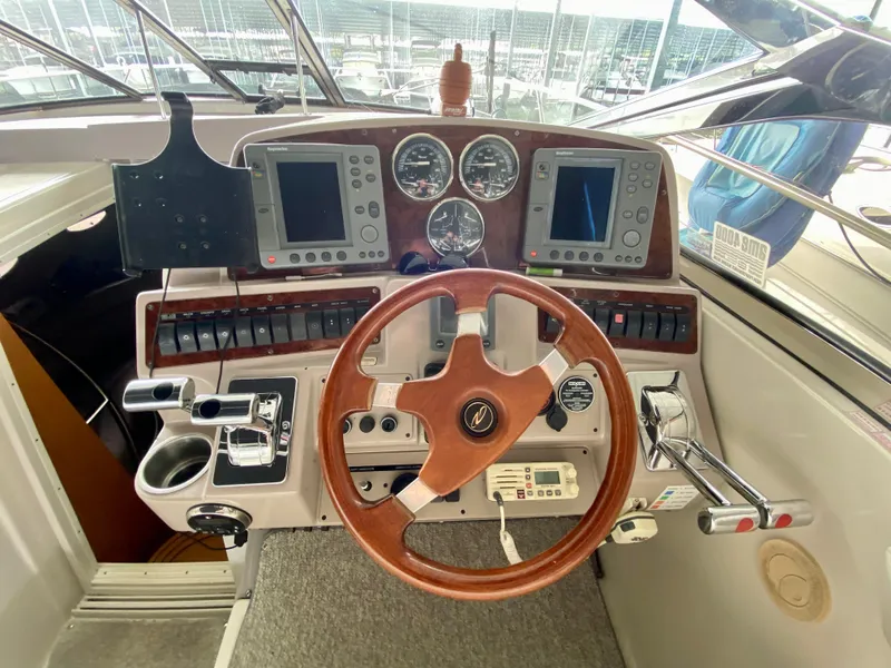 Slide: The Image of Control panel of a 2001 Regal Commodore 4160 yacht with wooden steering wheel and navigation instruments. - 23