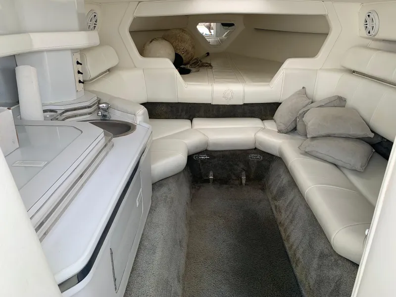 Slide: The Image of Interior of a 1996 Fountain 32 Fever boat with white seating and compact kitchenette. - 1