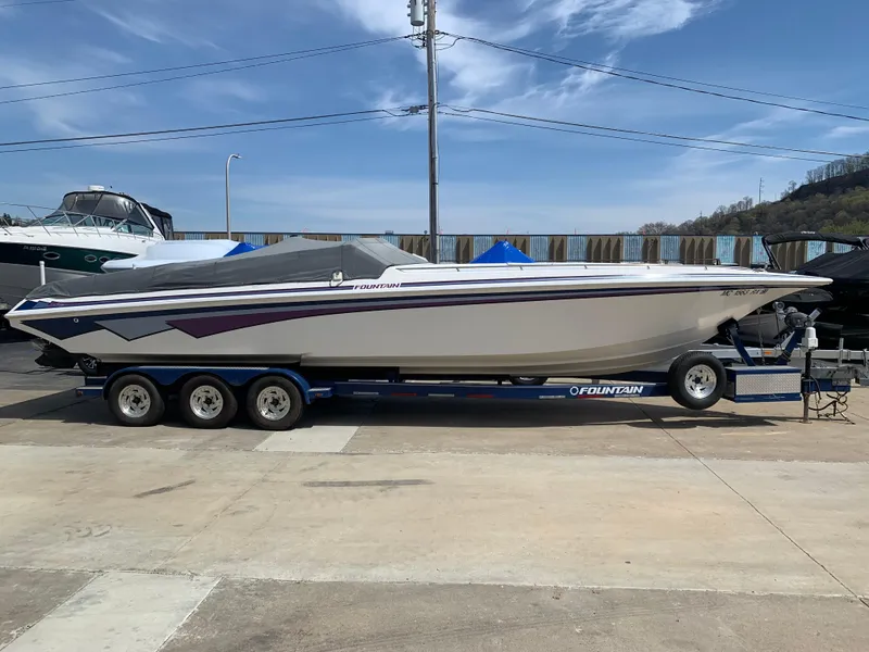 Slide: The Image of 1996 Fountain 32 Fever speedboat on trailer, parked outdoors under clear sky. - 14