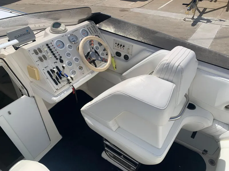 Slide: The Image of 1996 Fountain 32 Fever boat cockpit with white seating and control panel. - 6