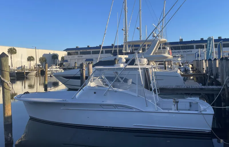 The Image of 2002 Miller Marine 36 Express boat on calm water, clear sky background. - 0