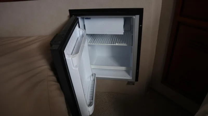 Slide: The Image of Open mini fridge inside 2002 Miller Marine Express boat cabin. - 13