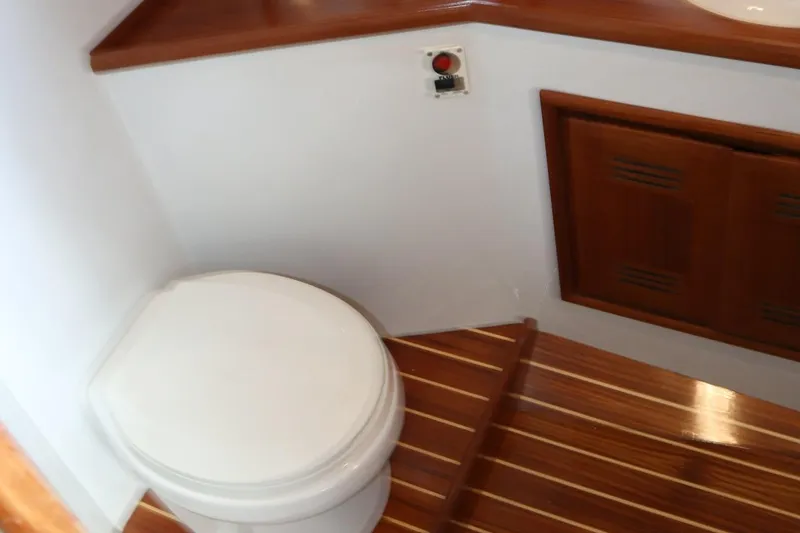 Slide: The Image of 2002 Miller Marine Express boat bathroom with wooden flooring and compact toilet. - 16