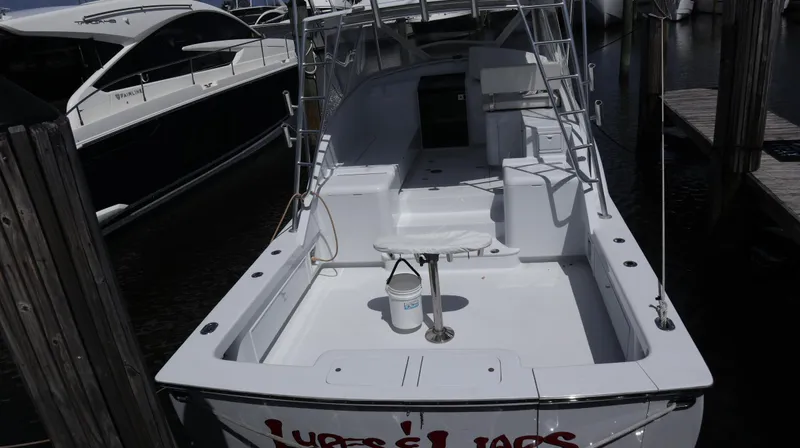 Slide: The Image of 2002 Miller Marine Express boat docked, featuring spacious deck and seating area. - 23