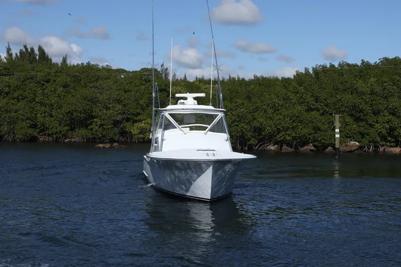 Slide: The Image of 2002 Miller Marine 36 Express boat cruising on a calm waterway with lush greenery. - 33