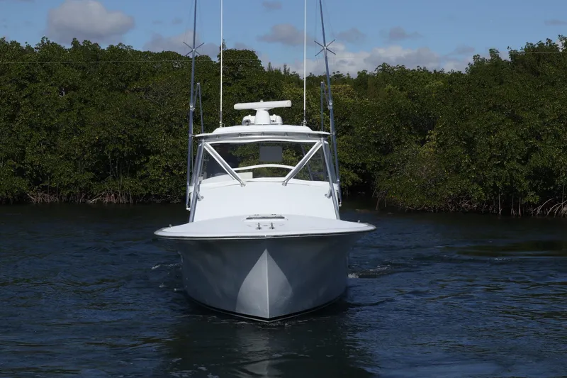 Slide: The Image of 2002 Miller Marine 36 Express boat navigating through calm waters, surrounded by lush greenery. - 37