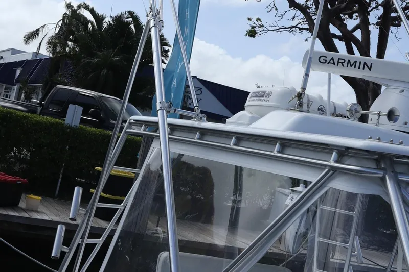 Slide: The Image of 2002 Miller Marine Express boat docked, featuring Garmin equipment, with trees and buildings in the background. - 8