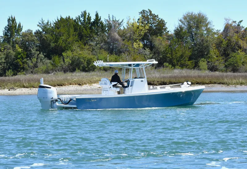 Slide: The Image of 2023 Pair Customs 24 Center Console MV boat cruising on a scenic waterway. - 0