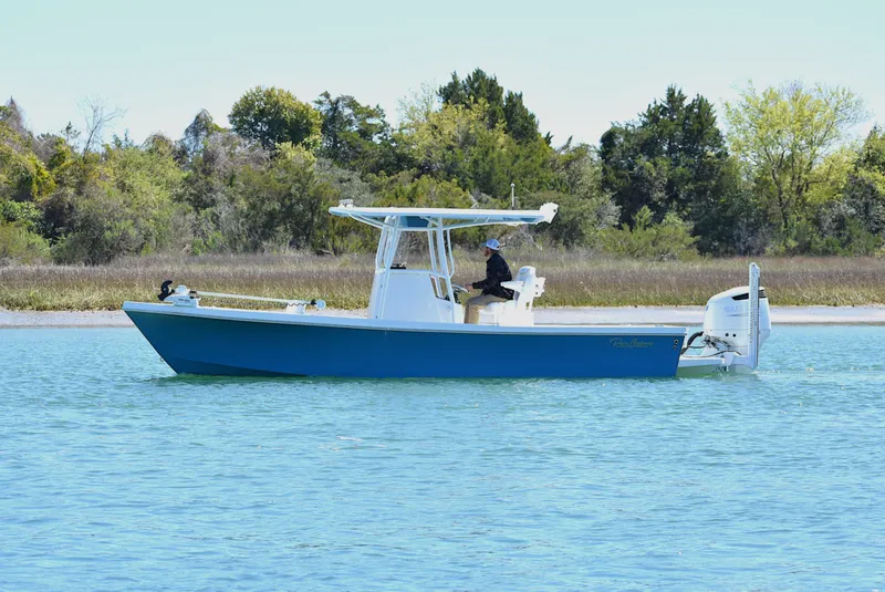 Slide: The Image of 2023 Pair Customs 24 Center Console MV boat on calm water near shoreline. - 1