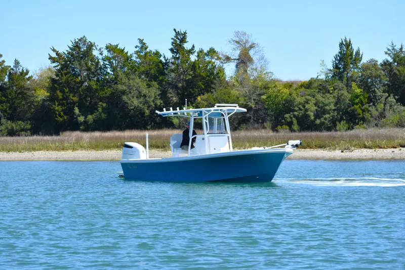 Slide: The Image of 2023 Pair Customs 24 Center Console MV boat cruising on a serene lake. - 10