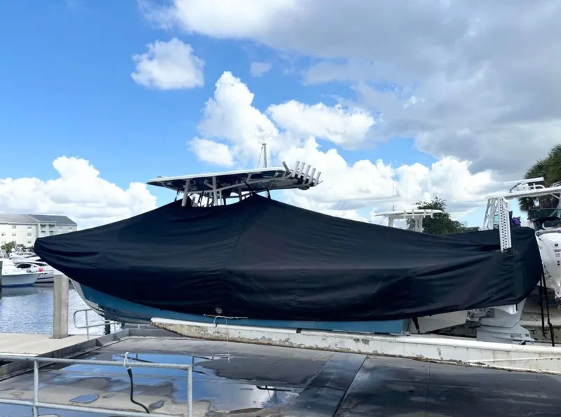 Slide: The Image of 2023 Pair Customs 24 Center Console MV boat covered at marina, under cloudy sky. - 11
