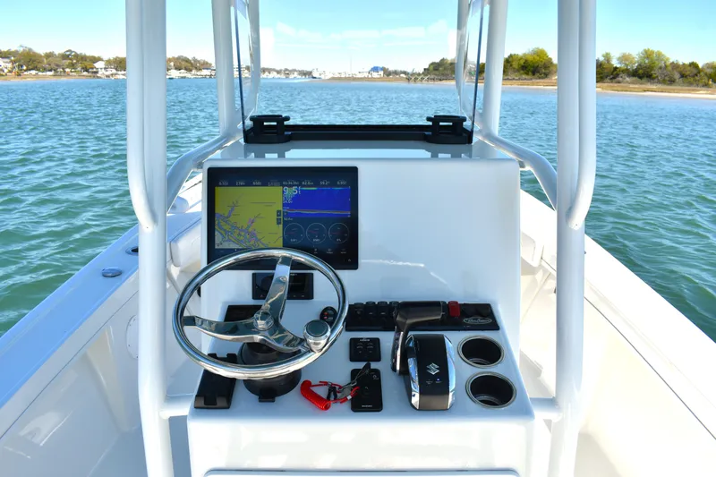 Slide: The Image of 2023 Pair Customs 24 Center Console MV boat dashboard with steering wheel and navigation display. - 22
