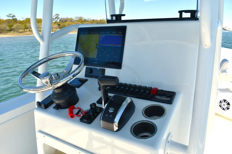 Slide: The Image of 2023 Pair Customs 24 Center Console MV boat dashboard with steering wheel and controls. - 25