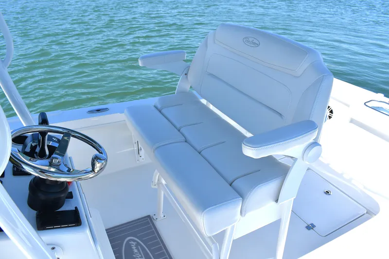 Slide: The Image of 2023 Pair Customs 24 Center Console MV boat with white seating and steering wheel on water. - 28