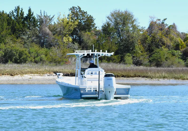 Slide: The Image of 2023 Pair Customs 24 Center Console MV boat cruising on a scenic waterway. - 4