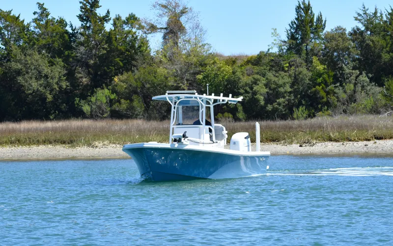 Slide: The Image of 2023 Pair Customs 24 Center Console MV boat cruising on a serene lake. - 8
