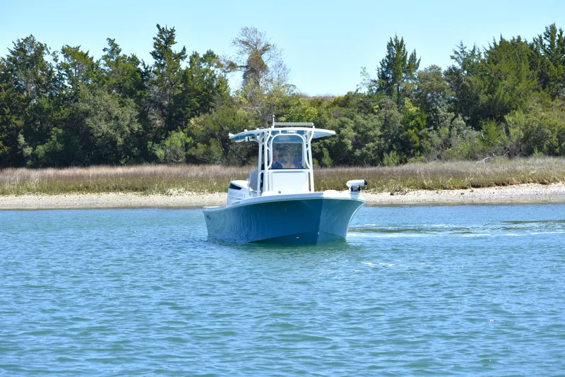 Slide: The Image of 2023 Pair Customs 24 Center Console MV boat on calm water near shoreline. - 9