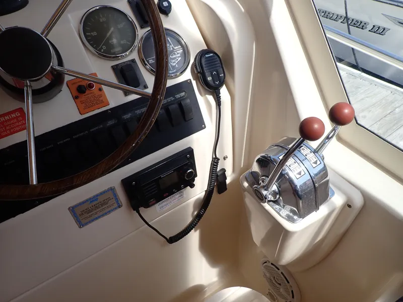 Slide: The Image of 2004 Mainship 34 Rum Runner II helm with steering wheel, controls, and radio equipment. - 17