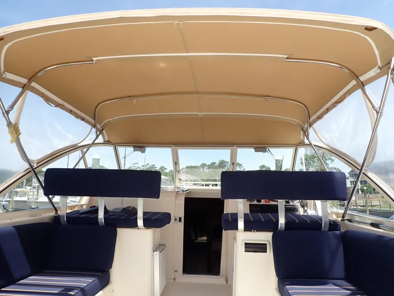 Slide: The Image of 2004 Mainship 34 Rum Runner II interior with blue seating and tan canopy. - 18