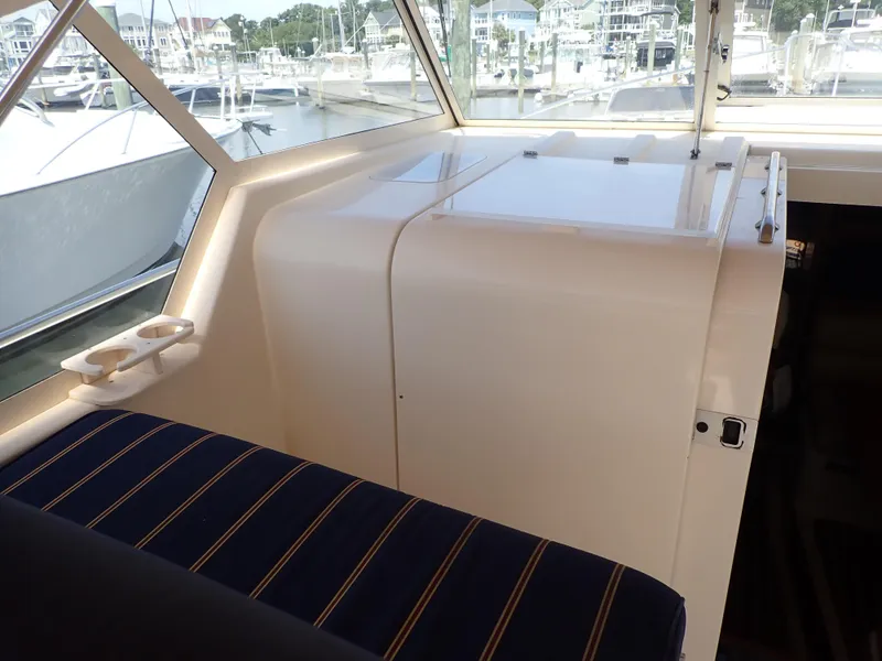 Slide: The Image of 2004 Mainship 34 Rum Runner II interior with striped seating and marina view. - 20