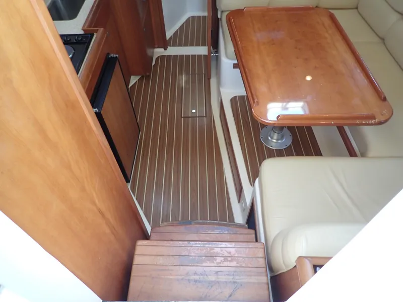 Slide: The Image of 2004 Mainship 34 Rum Runner II interior with wood flooring and dining area. - 21