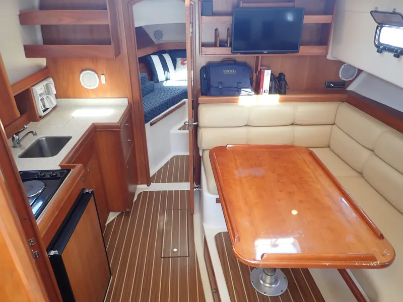 Slide: The Image of 2004 Mainship 34 Rum Runner II interior with kitchen, dining area, and cozy cabin. - 22