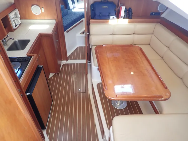 Slide: The Image of 2004 Mainship 34 Rum Runner II interior with kitchenette and dining area. - 23