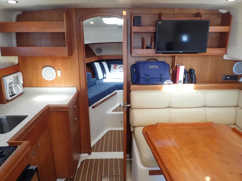 Slide: The Image of 2004 Mainship 34 Rum Runner II interior with kitchen, dining area, and cozy cabin. - 24