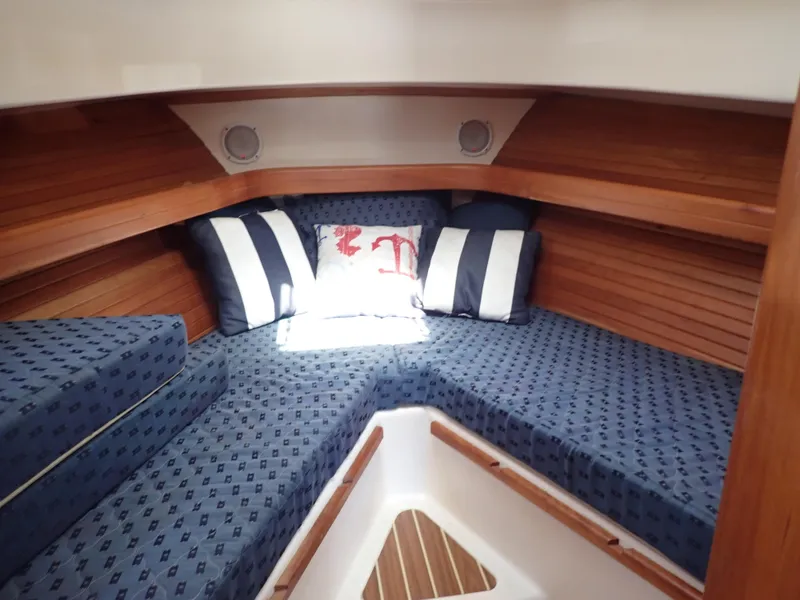 Slide: The Image of 2004 Mainship 34 Rum Runner II cabin with blue cushions and striped pillows. - 34
